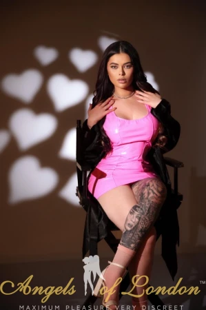 London escort Minola in pink latex sitting