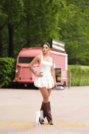 London escort Gella in white dress outside