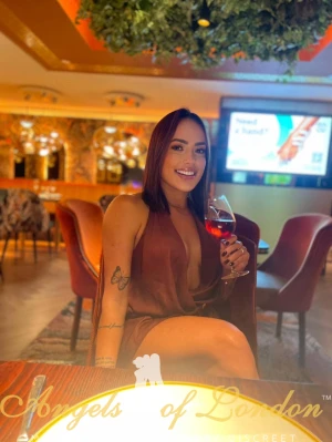 London escort Helma drinking wine
