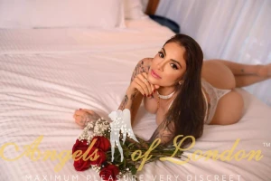 Brazilian escort Freesia on the bed with roses