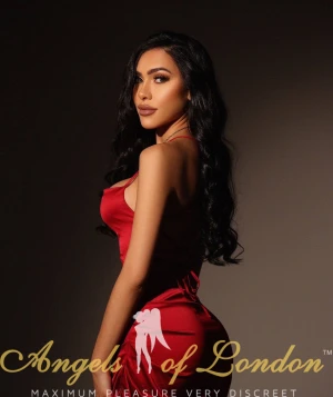 London escort Nomira in red dress from behind